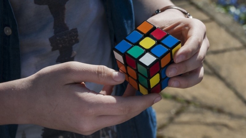 мальчик держит в руках кубик рубика